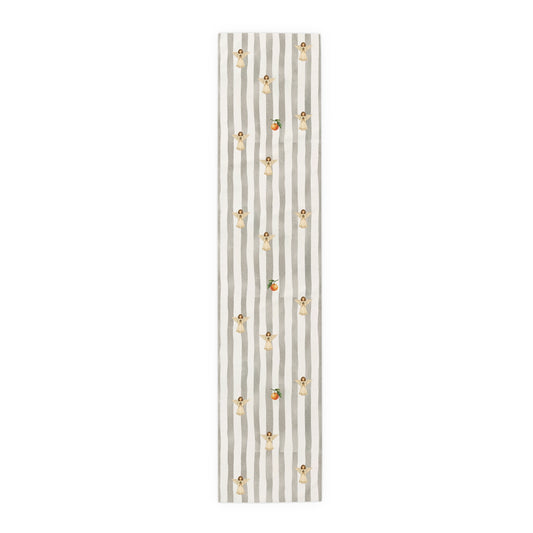 Grey and cream striped Christmas table runner with cream angels holding pine sprigs of red berries, and single oranges between them, laid flat