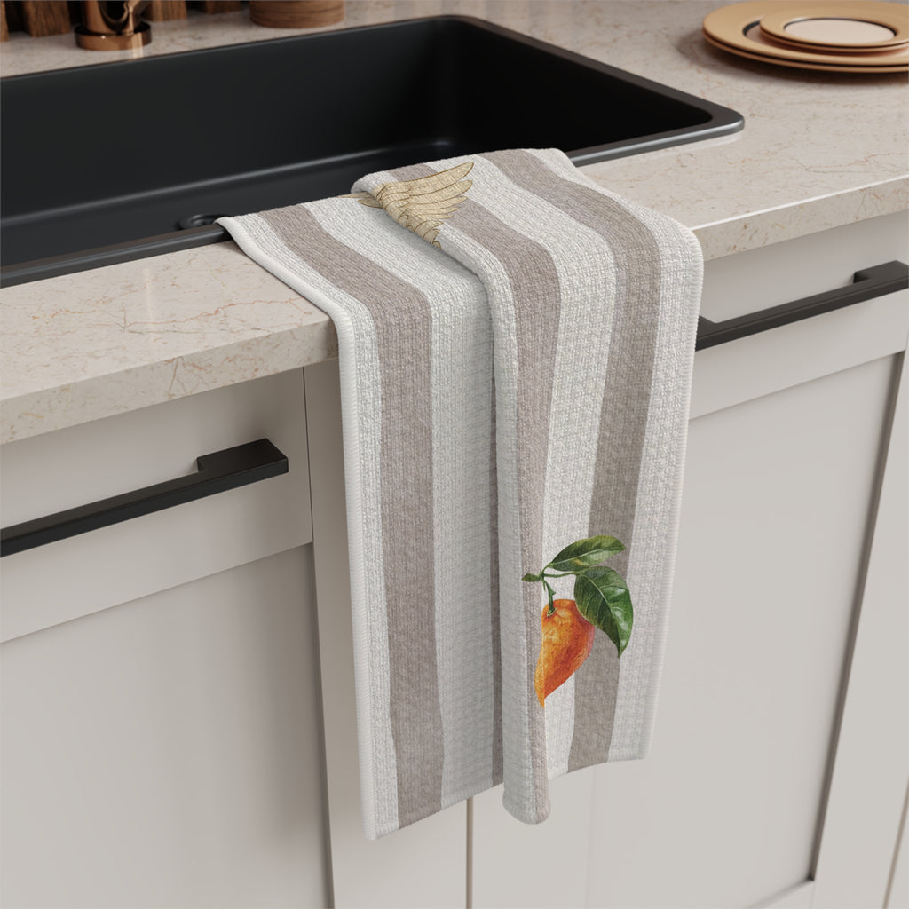 Angels and oranges Christmas tea towel draped over a kitchen counter beside a black sink