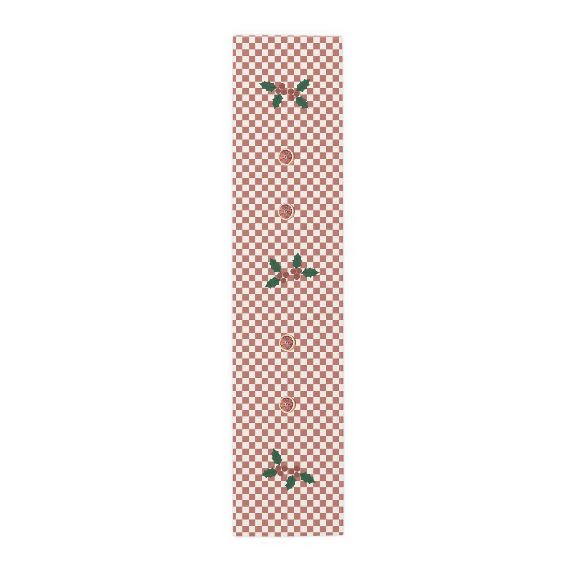 Blood orange check Christmas table runner laid flat, a red and cream checkerboard with holly and a cut blood orange