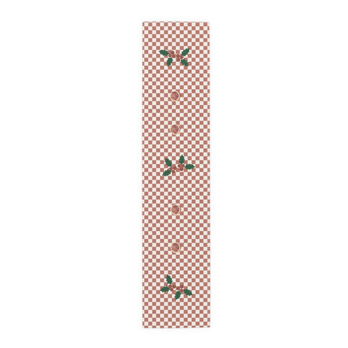 Blood orange check Christmas table runner laid flat, a red and cream checkerboard with holly and a cut blood orange