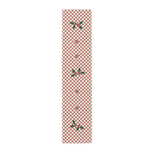 Blood orange check Christmas table runner laid flat, a red and cream checkerboard with holly and a cut blood orange