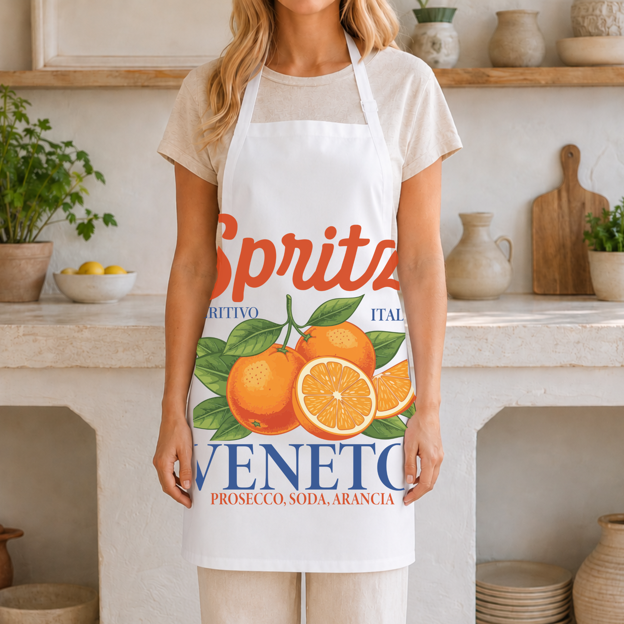 White Spritz Veneto apron worn in a bright kitchen with ceramics and a bowl of lemons