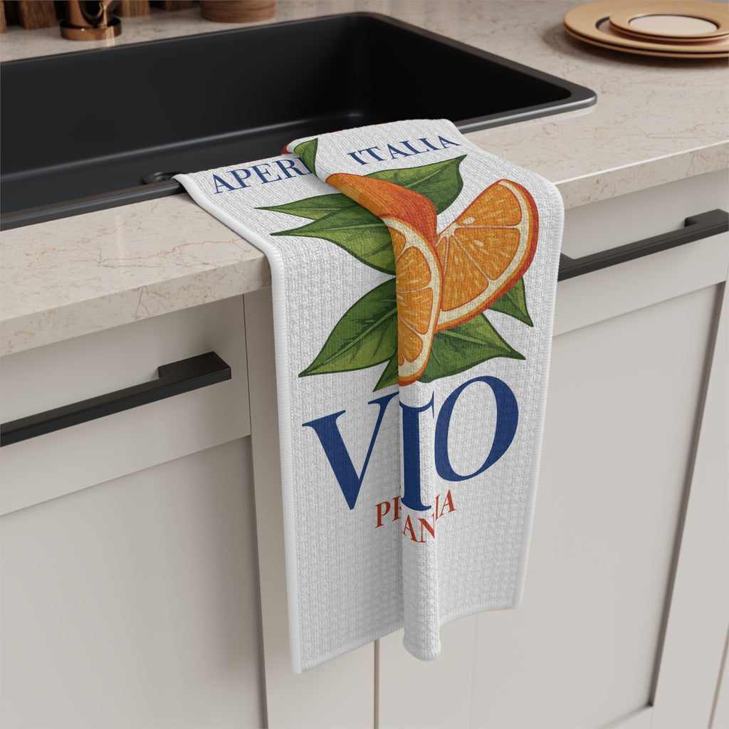 Spritz Veneto tea towel draped over the counter edge beside a dark kitchen sink