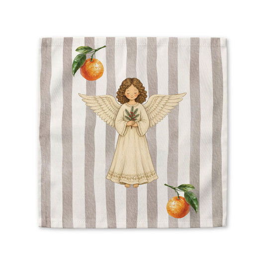 Angels and oranges Christmas cloth napkin laid flat, showing the angel and pine sprig on a soft grey stripe with oranges beside it