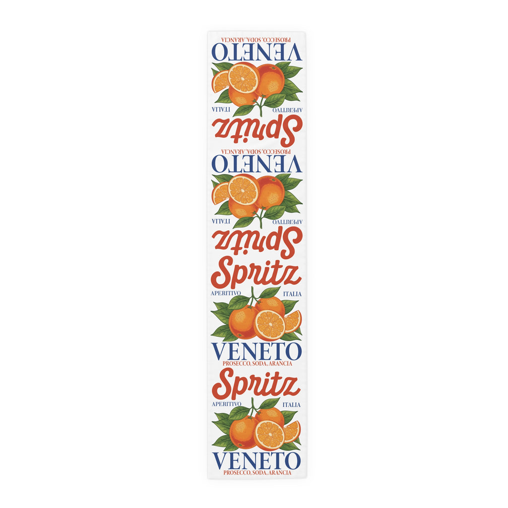 Spritz Veneto table runner, 16 by 72 inches in polyester, laid flat showing the repeating Spritz Veneto label print with oranges on a white ground