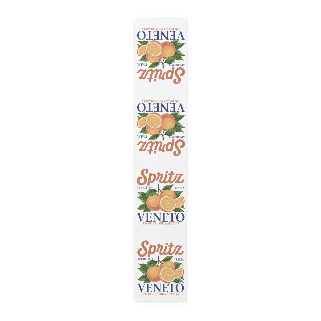 Spritz Veneto table runner, 16 by 90 inches in cotton twill, laid flat showing the repeating Spritz Veneto label print with oranges on a white ground