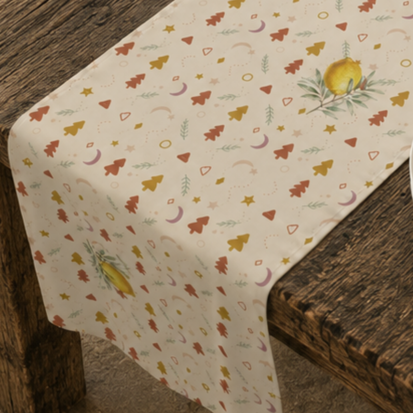 Close-up of the lemon and pine Christmas table runner, showing a watercolour lemon on its leafy branch between rust and gold trees