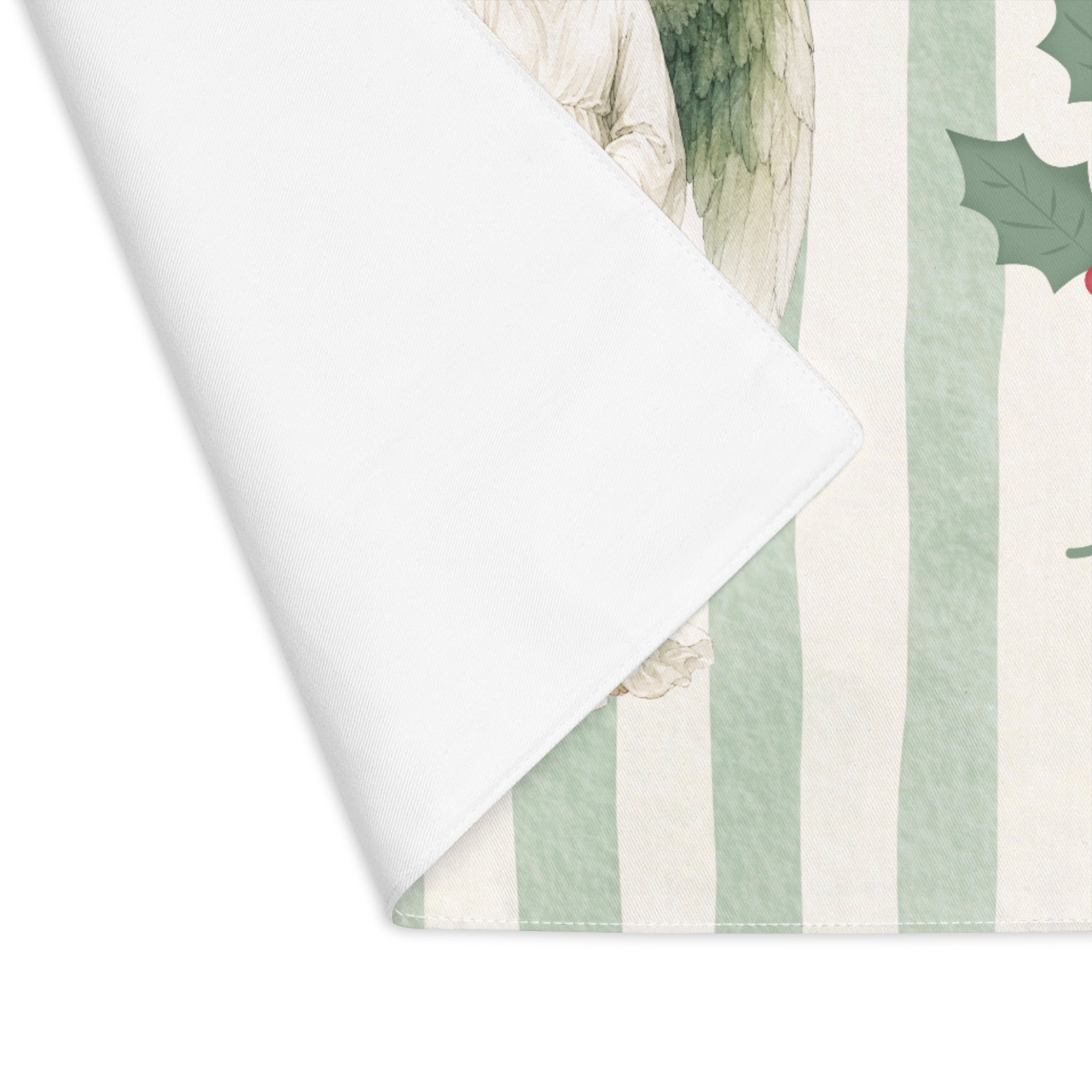 Corner of the Angels and holly placemat folded back, showing the stitched hem and the plain white reverse