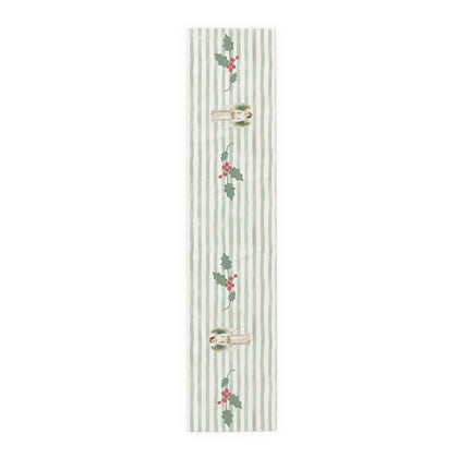 Angels and holly table runner, 72 inch in polyester, laid flat to show the angels and holly on a soft green stripe