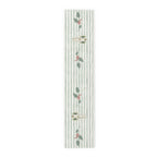 Angels and holly table runner, 72 inch in cotton twill, laid flat to show the angels and holly on a soft green stripe
