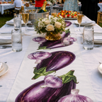 Eggplant and Garlic table runner down a long white banquet table set with flowers and glasses