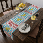 Limoncello Amore Mio table runner on a dark wooden table with chairs, lemons and tall glasses