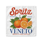 Spritz Veneto cloth napkin, 10 by 10 inches, laid flat showing the Spritz Veneto label print with oranges on a white ground