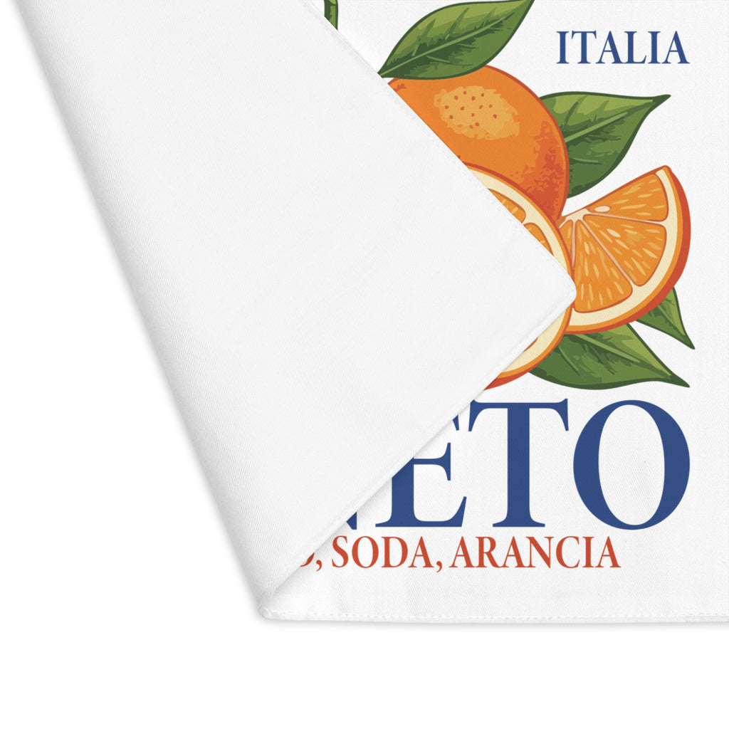 Corner of the Spritz Veneto placemat folded back, showing the stitched hem and the woven fabric surface